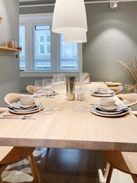 Table set up for dinner and the minimalistic interior in pastel color tones