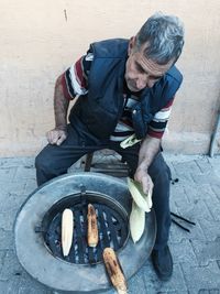 High angle view of man grilling corns at street