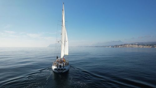 Sailboat sailing on sea against sky