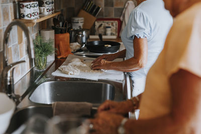 Mid section of senior women preparing food in kitchen