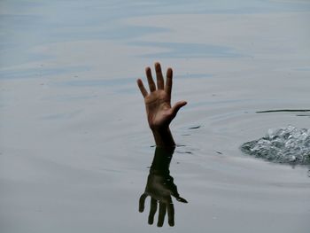 Close-up of hand drowning in sea