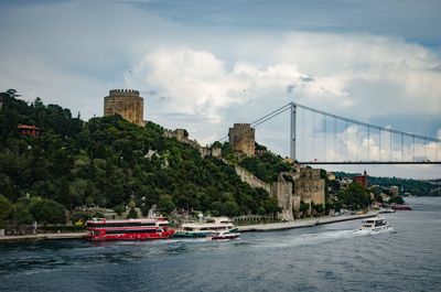 Boats in river with city in background