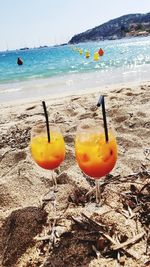 Close-up of drink on beach against sky