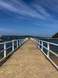 Bridge over calm sea against sky