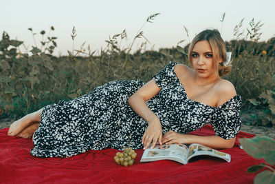 Portrait of young woman sitting on field