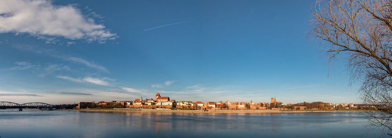 Scenic view of lake by buildings against sky