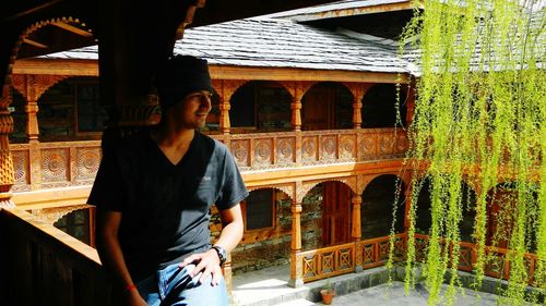 Woman standing on wooden wall