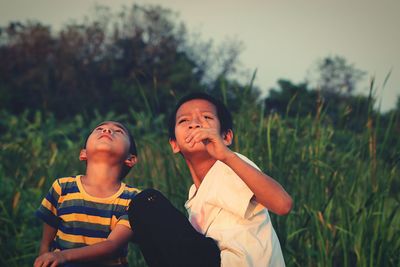 Boys looking up while siting on field