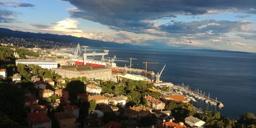 High angle view of sea by city against sky