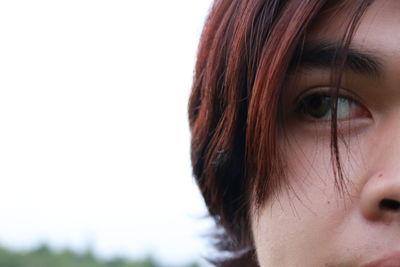 Close-up of young woman looking away against clear sly