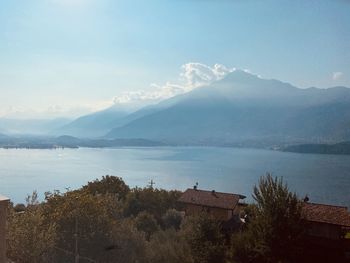 Scenic view of sea by mountains against sky