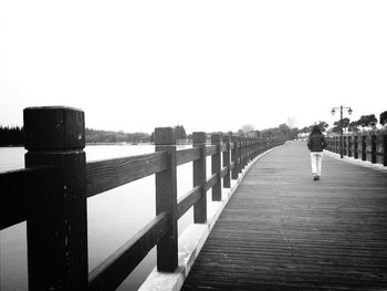 Pier on river against clear sky