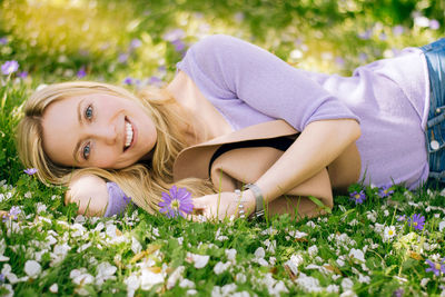 Portrait of young woman lying on grass