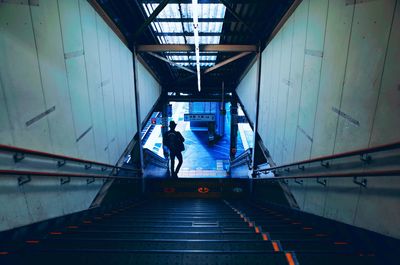 Rear view of people walking on staircase