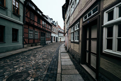 Empty walkway amidst residential buildings