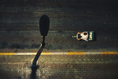 Directly above shot of man riding pedicab on road at night