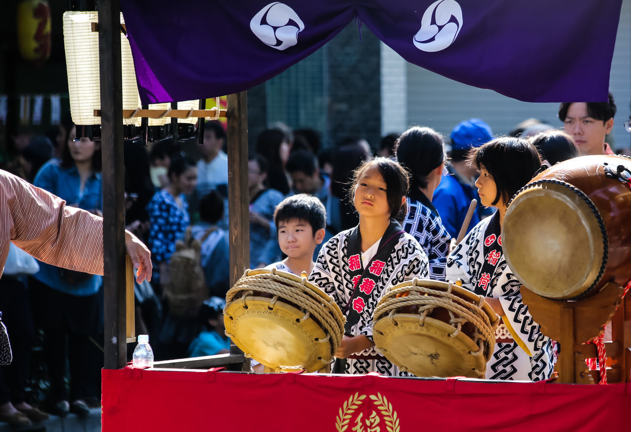 real people, musical instrument, music, men, large group of people, marching band, celebration, parade, day, outdoors, drum - percussion instrument, standing, musician, arts culture and entertainment, boys, women, togetherness, lifestyles, people