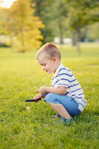 Boy crouching on field