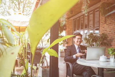 Young businessman using laptop while drinking black coffee at table in cafe