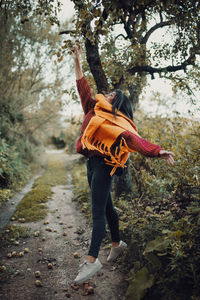 Rear view of woman standing in forest