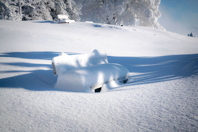 Frozen park bench covered in deep snow in beautiful winter wonderland, salzburg, austria.