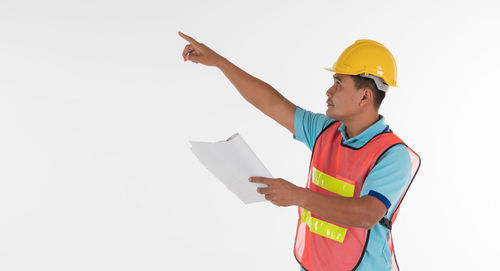 Man holding umbrella standing on paper against white background