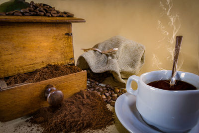 High angle view of coffee maker with beans on beige background