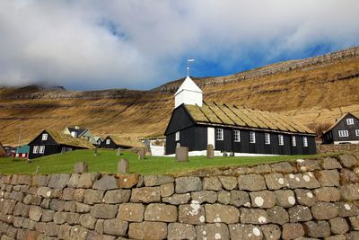 Houses by mountain against sky