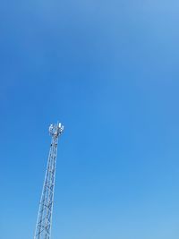 Low angle view of crane against clear blue sky