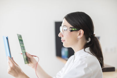 Scientist female with lab glasses, tablet and sample in a lab