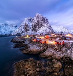 Illuminated houses against mountains at dusk