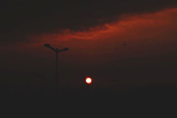 LOW ANGLE VIEW OF STREET LIGHT AGAINST SKY AT SUNSET