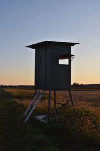 Built structure on field against sky during sunset