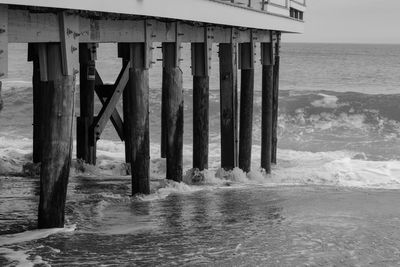 Scenic view of pier on beach against sky