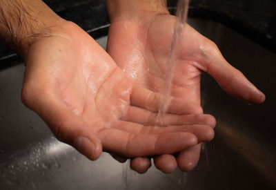 Close-up of hands on wet floor