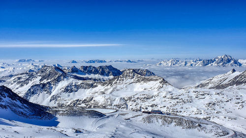 Scenic view of snowcapped mountains against blue sky