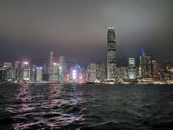 Illuminated buildings in city against sky at night