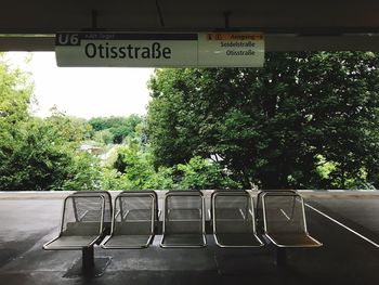 Information sign over empty seats at railroad station platform