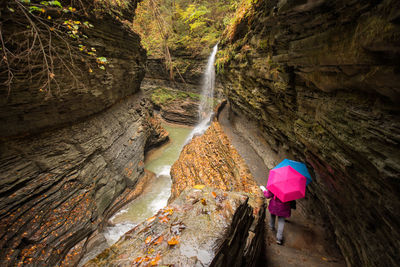 Low section of person by waterfall at forest