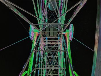 Low angle view of illuminated ferris wheel against sky at night