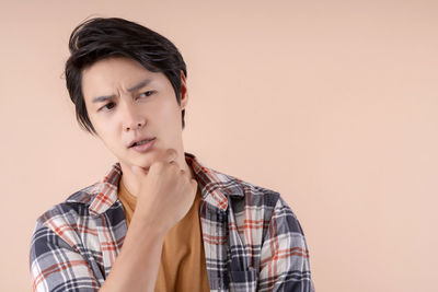 Portrait of young man against gray background