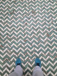 Low section of man standing on tiled floor