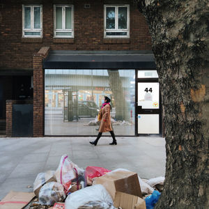 Full length of man standing on footpath by building