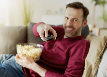 Happy man sitting on sofa at home