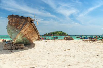 Boats moored on beach against sky