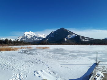 Scenic view of snowcapped mountains against blue sky