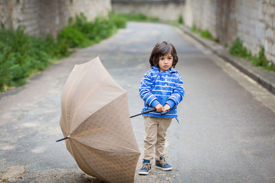 Little eastern handsome baby boy playing with umbrella outdoor