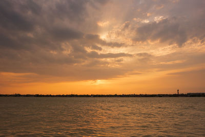 Scenic view of sea against dramatic sky during sunset