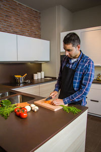 Young woman standing by kitchen at home
