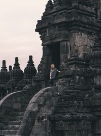 Woman standing by old ancient temple